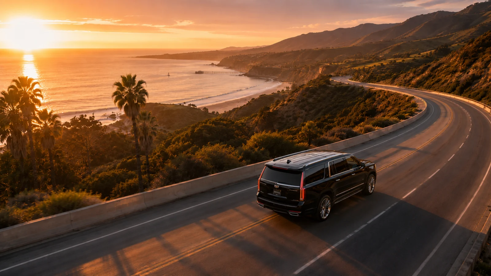 Black Cadillac Escalade on the Pacific coast highway at sunset — Los Angeles to Santa Barbara car service